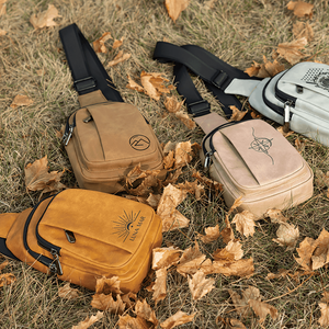 Four bags in different colors on a grassy surface with leaves