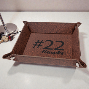 Brown leather tray with '#22 Hawkes' text on a white surface