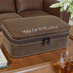Brown leather travel case with 'Enjoy life to the fullest' text on a wooden table.