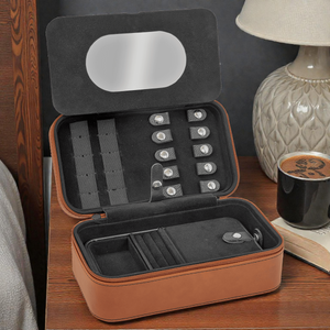 Open jewelry case on a wooden surface with a cup of coffee and lamp in the background