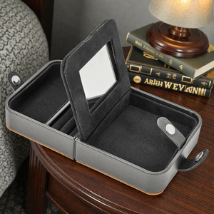 Gray jewelry case with mirror on a wooden surface
