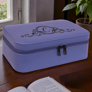 Purple jewelry box with decorative emblem on a wooden surface