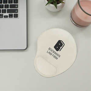 Mouse pad with 'Bookman Law Firm' logo on a desk with laptop and glass.