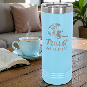 Light blue tumbler with 'Travel Airlines' design next to a steaming cup of coffee on a wooden table.