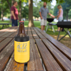 Bottle with a yellow sleeve on a wooden table in a park setting with people in the background.