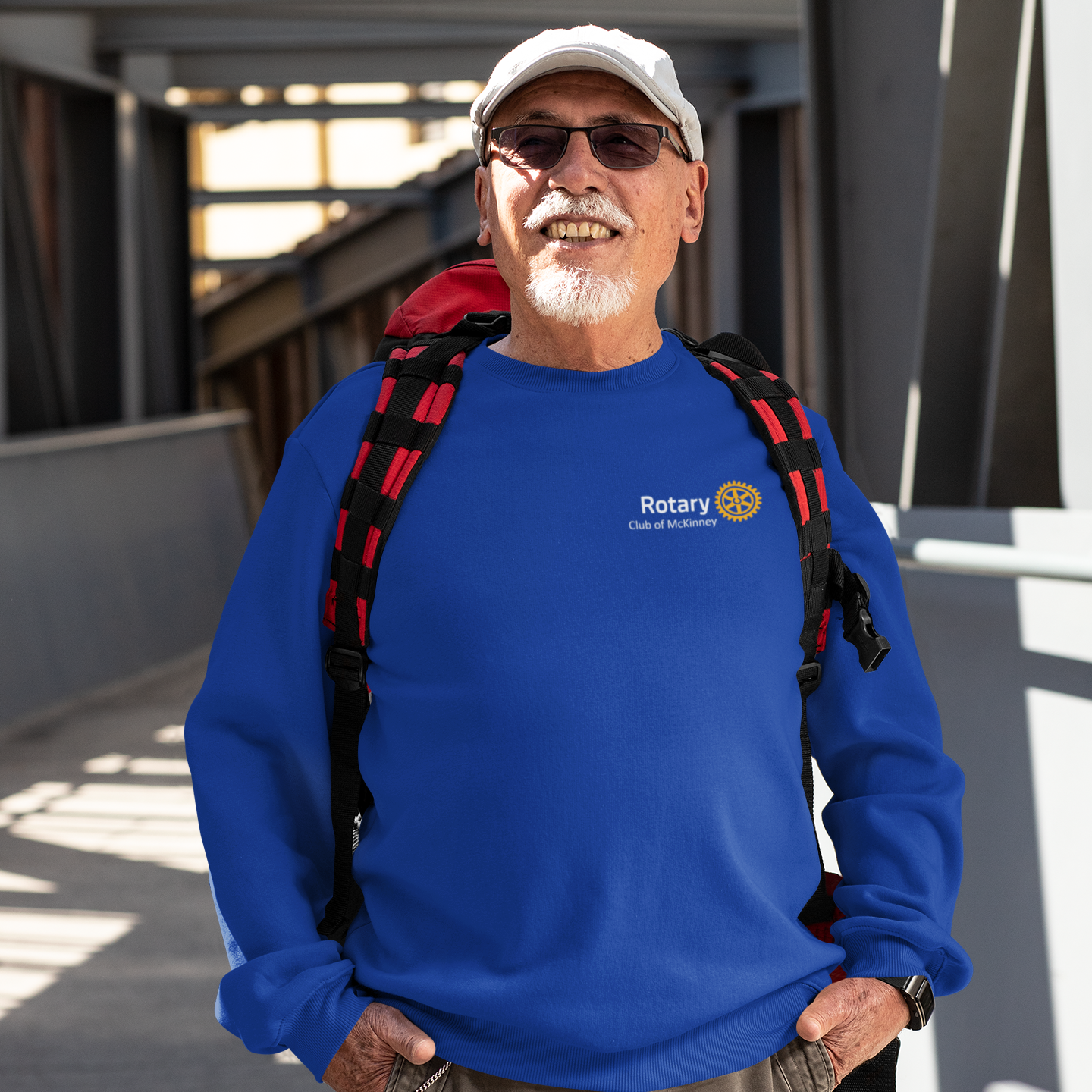 Man wearing a blue sweatshirt with a Rotary logo, standing outdoors.